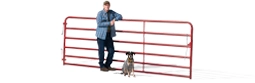 Profile of a man leaning against a red fence with his dog sitting next to him.
